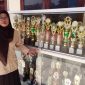 HJ Romlah, Kasek MI Miftahul Huda memperlihatkan sederet piala prestasi siswanya. (FOTO : Sudibyo/Harian Sederhana)