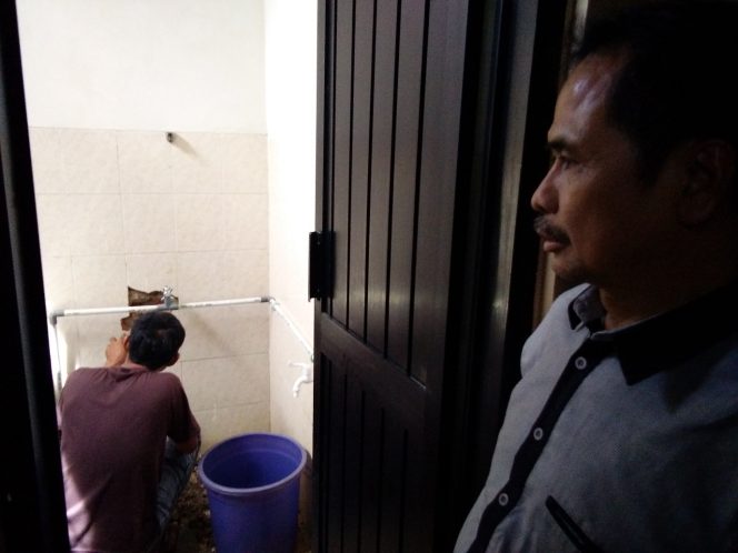 
					Camat Bojongsari, Usman Haliyana sedang melihat perbaikan toilet.(FOTO : Sudibyo/Harian Sederhana)