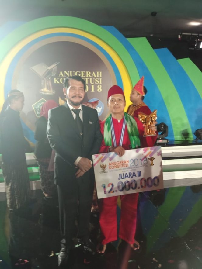 
					Waka Bidang Kesiswaan SMPN 10 Depok, Haryanto menerima hadiah sebagai juara 3 di ajang lomba tingkat nasional. (FOTO : Sudibyo/Harian Sederhana)