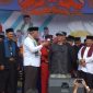 Wali Kota Depok, Mohammad Idris memberikan hadiah sebuah handphone kepada Kong Mita, peserta Festival Budaya Bojongsari. (FOTO : Istimewa)