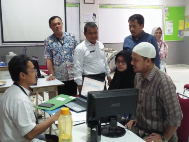 
					Kasi Pelayanan Cabang Dinas Pendidikan Wilayah 2 Jabar, Saptari  (dua kiri, berdiri), mendampingi  Kepala SMAN 1 Kota Bogor, Dr. R. Bambang Aryan saat ini PPDB online. (FOTO : BP.Sianturi/Harian Sederhana)