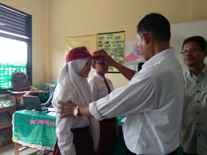 
					Guru melepas topi siswa secara simbolis mendandai pelepasan siswa setelah lulus dari sekolah dasar di SDN Sawangan 01.(FOTO :  Sudibyo/Harian Sederhana)