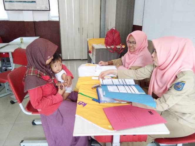 
					Panitia PPDB SDN Bedahan 01 tengah menerima orang tua siswa yang mendaftaran anaknya di sekolah tersebut. (FOTO : Sudibyo/Harian Sederhana)