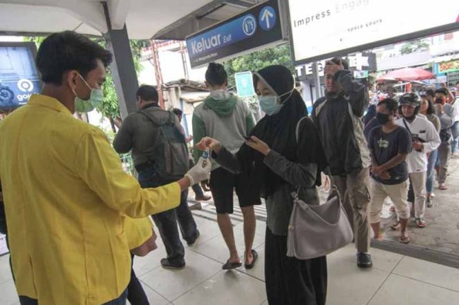 
					Para mahasiswa Universitas Indonesia di kawasan Beji membagikan hand sanitizer. (FOTO : Istimewa)