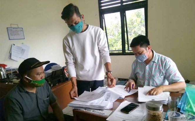 
					Rizal Antoni sedang melihat data warga penerima bantuan di Kelurahan Bedahan.