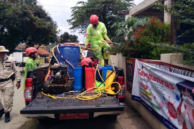 
					Petugas Damkar dan Satpol sedang menyemprot disinfektan di depan kantor Kelurahan Serua, Kecamatan Bojongsari.