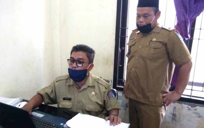 
					Lurah Pasir Putih, Ahmad Rifa’I (kanan) bersama Sekkel Umar sedang mendata kepala keluarga miskin dan rentan miskin.