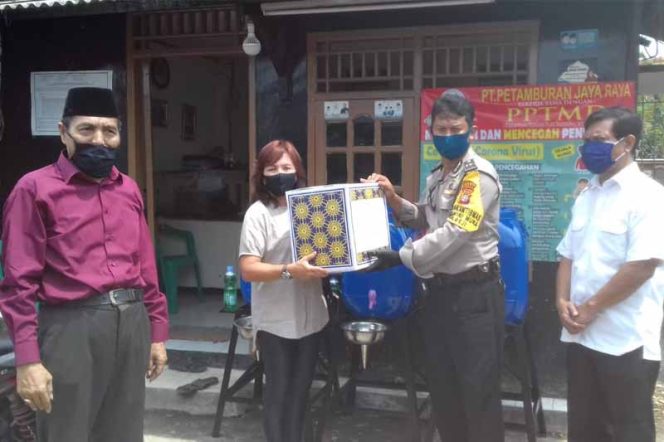 
					Manajemen PT Petamburan Jaya Raya usai menyerahkan tempat cuci tangan dan ratusan masker membentangkan spanduk cegah Covid-19.