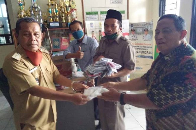 
					Lurah Kedaung, Wahidin (kiri) menerima bantuan masker.