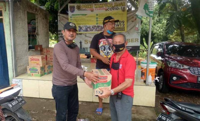 
					Martin Badri (kanan) , Ketua RW 06, Kelurahan Pondok Petir menyerahkan bantuan ke Posko Banjir. 