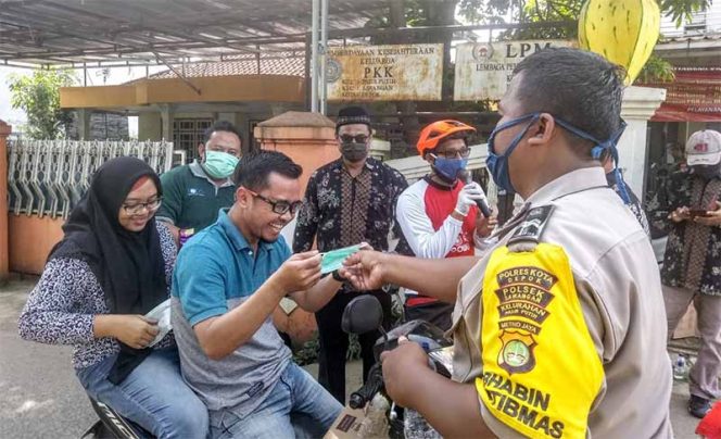 
					Bhabinkamtibmas Kelurahan Pasir Putih menyerahkan masker kepada pengendara di Jalan Raya Pasir Putih.