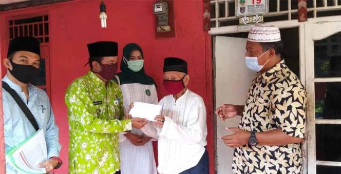 
					Lurah Dumek, Muhammad Sahal menyerahkan bantuan berupa uang kepada warga.