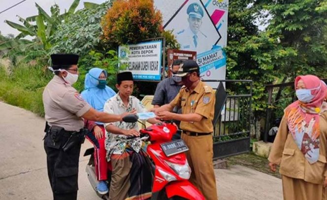 
					Lurah Dumek, M Sahal saat memberikan masker kepada penggendara.